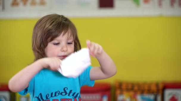 Närbild porträtt av en liten långhårig pojke bär en mask — Stockvideo