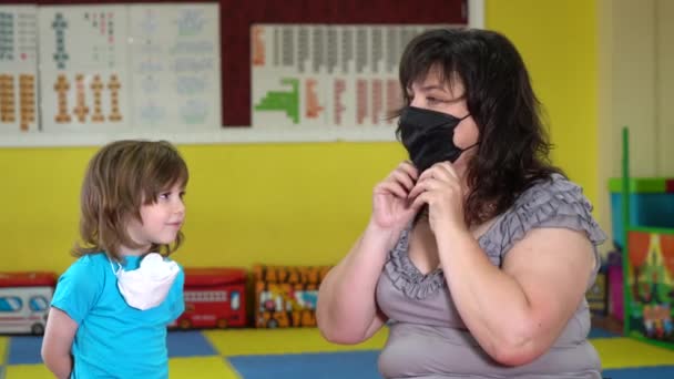 Conceito, família durante a quarentena auto-isolamento. Mãe coloca seu filho em uma máscara para proteção . — Vídeo de Stock