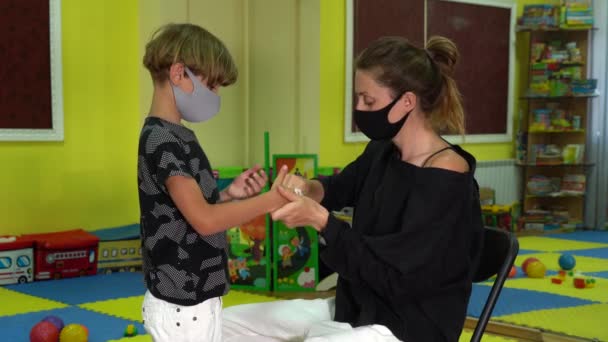 Uma menina limpa as mãos de seus filhos com uma toalhita antibacteriana — Vídeo de Stock