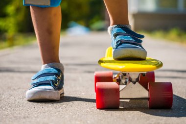 Bacak vardır bir kaykay üzerinde yakın. Küçük bir çocuk bir sürüş için hazırlanıyor