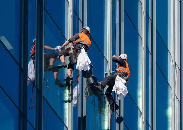 Window washers cleaning the glass facade of a skyscraper