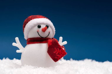 Mavi arka plan üzerinde gösterisinde mutlu kardan adam