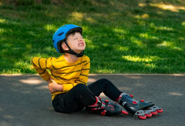 A boy fell with the roller skates and hit his back and hip
