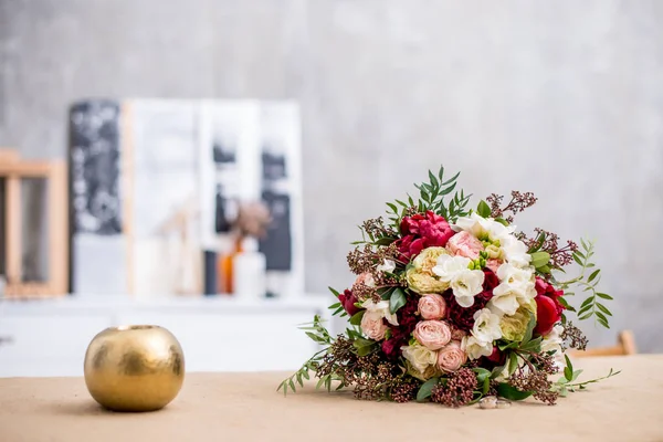 beautiful modern wedding bouquet on the table. Against the gray wall.