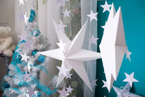White paper stars on blue background. New Year\'s interior. Christmas decorations.