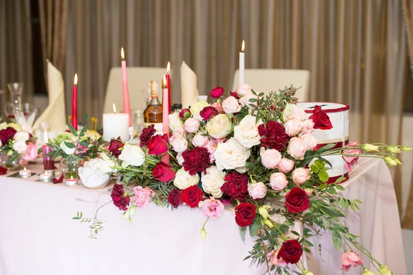 婚礼桌装饰用红色的花朵和蜡烛 — 图库照片