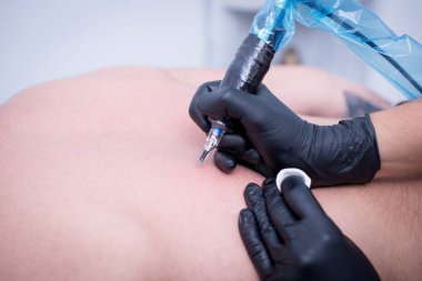 El yeni bir dövme yapmak hazırlanıyor.