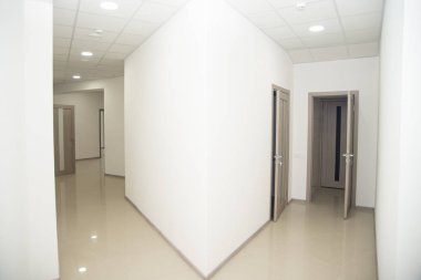 Boş ofis koridoru ve bir sürü odun kapısı var..
