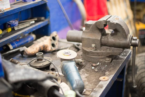 Metal workshop. Vise and bench grinder on metallic workbench. Copy space.