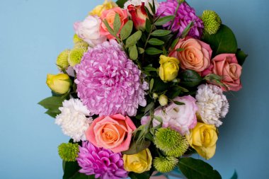 güzel çiçek düzenleme, pembe ve sarı gül, pembe eustoma, yeşil ve pembe krizantem, metin için yer bir mavi, Turkuaz zemin üzerine beyaz karanfil, pembe dahlia