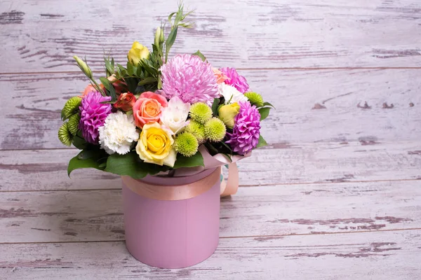 güzel çiçek aranjmanı kutusu, pembe ve sarı gül, pembe eustoma, yeşil ve pembe krizantem, beyaz karanfil, dahlia ahşap arka plan, üstten görünüm üzerinde metin için yer.