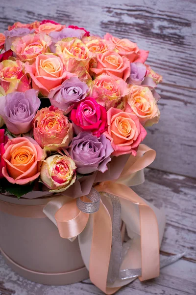 Beautiful bouquet of roses in a gift box. Bouquet of pink roses. Pink roses close-up. on wooden background, with space for text.