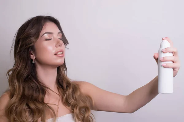 Güzel bir kadın yüzüne sprey yüz losyonu kozmetik beyaz adam üzerinde üzerinde.