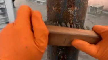 Adam metalik bir profili kahverengi boyayla boyuyor..