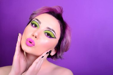 Kısa saçlı seksi bir kız. Parlak renkli saçlı, mor tonlarda bir kadının portresi. Güzel dudaklar ve makyaj. Dudak şeklinde tüp. Profesyonel boyama. profesyonel makyaj.