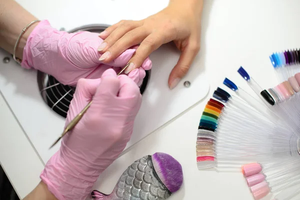 Gros plan d'une femme dans un salon de manucure recevant une manucure par un esthéticien avec lime à ongles. Une femme qui se fait manucure. Clous de lime esthéticienne à un client . — Photo