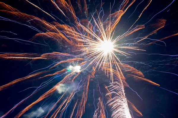 Een paar volleys van feestelijke vuurwerk in de nachtelijke hemel, rood-geel. — Stockfoto