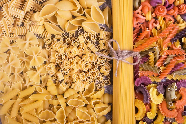 Raw pasta background, close-up. Close-up of pasta in different shapes and forms. Different types of pasta close-up