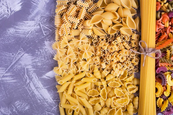 Solid and colored pasta, place for text. Place near macaroni of different shapes. Paste the text