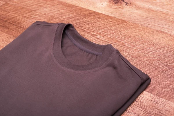 Folded brown T-shirt on laminate. Cotton shirt is brown. Put shirt on the hike