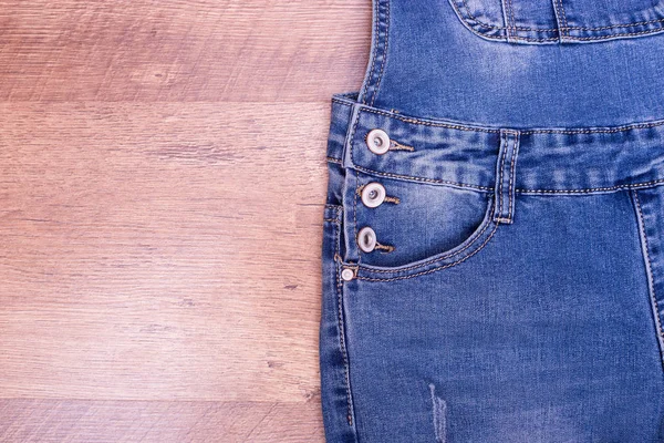 Jeans overall close-up. Pocket of denim overalls, place for text. Women's clothing from jeans