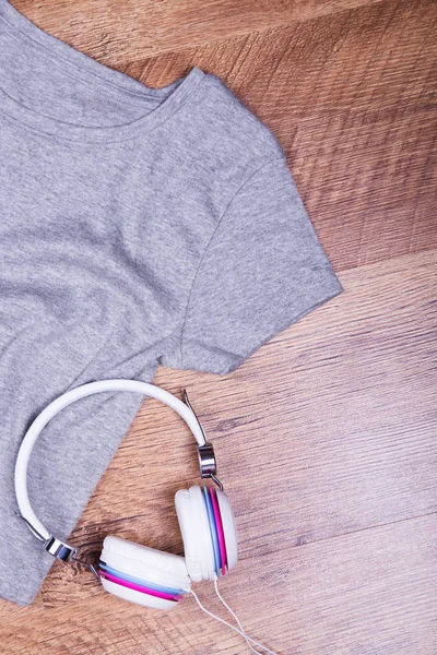 Gray T-shirt and white headphones. Summer shirt and bright headphones