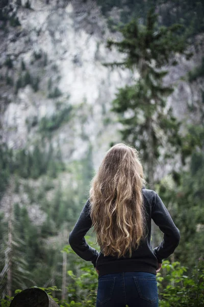 Back of young woman in mountains. Stylish hipster woman looking at amazing mountains. Park in the Tatras
