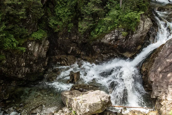 Waterfall, divided into two streams. Mountain waterfall in distance