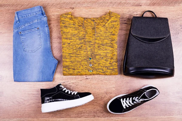 Keds, jeans, sweater and backpack. Autumn look with sweater and accessories