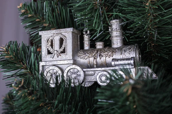 Christmas toy train on Christmas tree. Rich New Year toy on branch