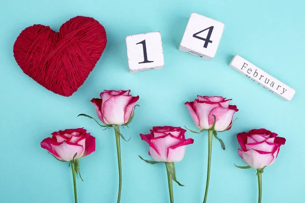 Roses, red heart, wooden calendar. Flowers and heart on 14 of february