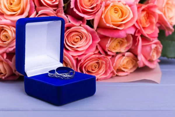 Beautiful box with jewels and orange flowers. Roses and blue gift box with ring