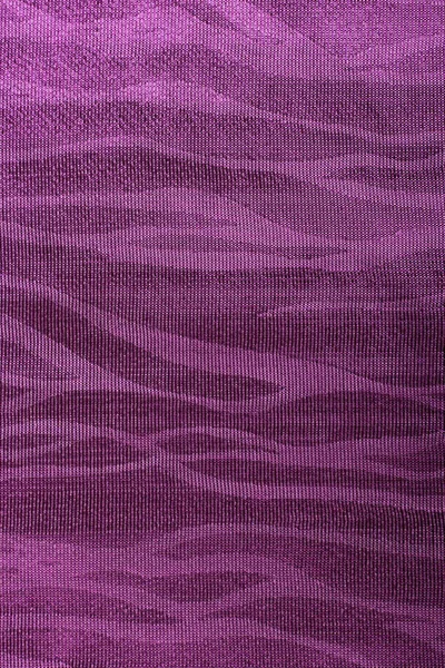 Background of purple fabric with patterns. Piece of bright purple fabric