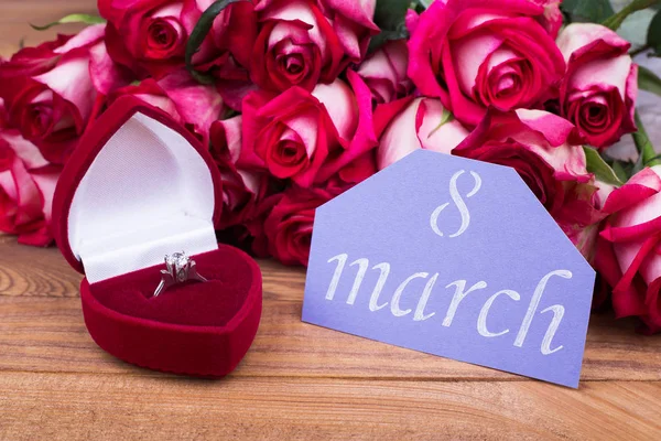 8 march card, ring in box and roses. Red box with ring, roses and greeting postcard