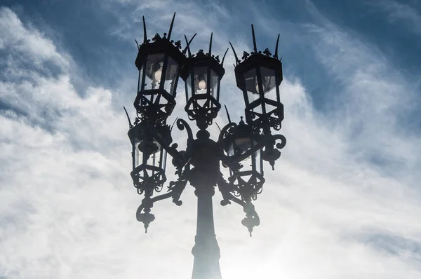 Antique street lamp against background of clouds