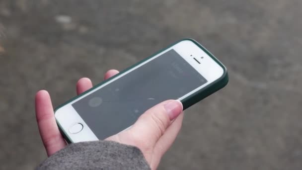 Een jong meisje beantwoordt een oproep met haar vinger op het touchscreen. Ze gebruikt een smartphone, die ze in haar hand houdt. close-up meisje neemt een inkomende oproep van mam. — Stockvideo