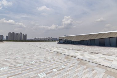Panoramik siluet ve boş yolu, boş beton zemini olan modern iş binaları.