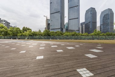 Panoramik siluet ve boş yolu, boş beton zemini olan modern iş binaları.