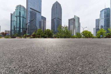 Panoramik siluet ve boş yolu, boş beton zemini olan modern iş binaları.