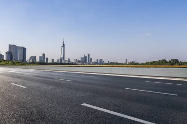 Panoramik siluet ve boş yolu, boş beton zemini olan modern iş binaları.
