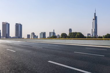 Panoramik siluet ve boş yolu, boş beton zemini olan modern iş binaları.