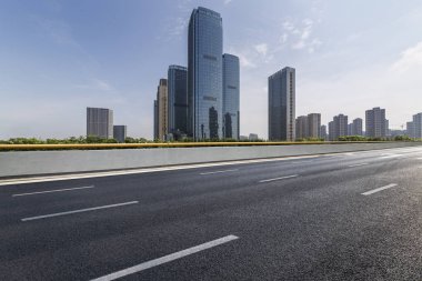 Panoramik siluet ve boş yolu, boş beton zemini olan modern iş binaları.