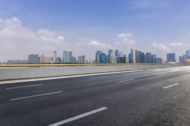 Panoramik siluet ve boş yolu, boş beton zemini olan modern iş binaları.