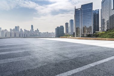 Panoramik siluet ve boş yolu, boş beton zemini olan modern iş binaları.