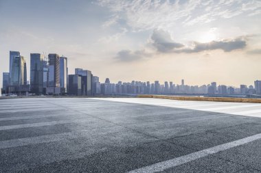 Panoramik siluet ve boş yolu, boş beton zemini olan modern iş binaları.