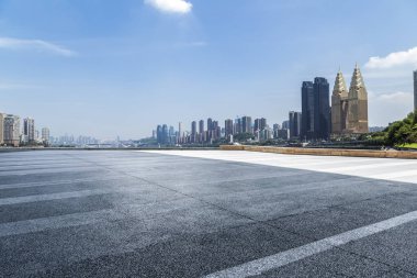 Panoramik siluet ve boş yolu, boş beton zemini olan modern iş binaları.