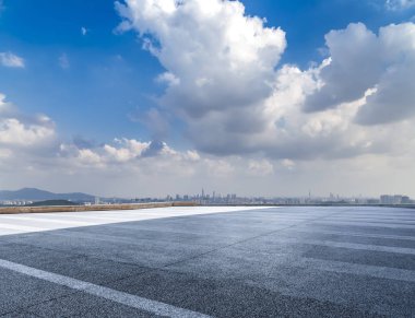 Panoramik siluet ve boş yolu, boş beton zemini olan modern iş binaları.