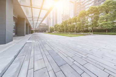 Panoramik siluet ve boş yolu, boş beton zemini olan modern iş binaları.