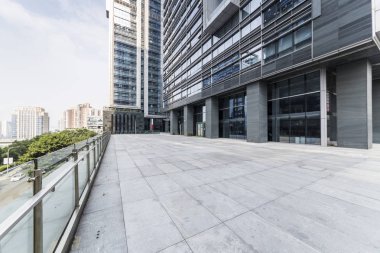 Panoramik siluet ve boş yolu, boş beton zemini olan modern iş binaları.