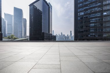 Panoramik siluet ve boş yolu, boş beton zemini olan modern iş binaları.